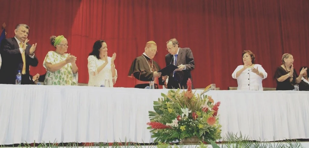 El cardenal Miguel Obando Bravo recibe la presea que lo distingue como “prócer de la paz y la reconciliación“ otorgada por la Asamblea Nacional de Nicaragua en una ceremonia oficial. La referencia completa en el texto.